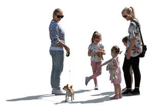 backlit group of women and children and a dog