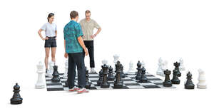 three young people playing street chess