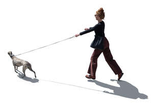 backlit woman running after a dog