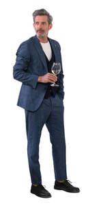 man in a suit standing and drinking wine
