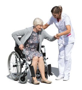 nurse helping an elderly woman sitting in a wheelchair to stand up