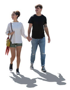 backlit latino couple walking hand in hand
