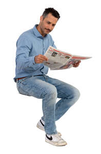 man with moustache sitting and reading a newspaper