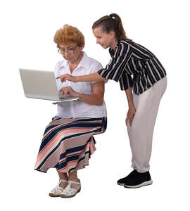 girl showing her grandmother how to use a computer