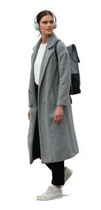 woman in a grey overcoat and with headphones