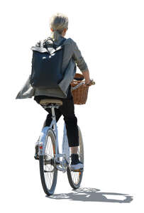 backlit woman with a backpack riding a city bike
