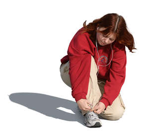 young woman squatting and tying her shoelaces