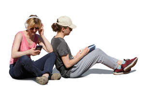 two people sitting on the ground and reading