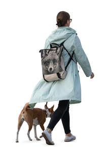 woman in an autumn jacket walking a dog
