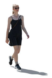 backlit woman in a black mini dress walking