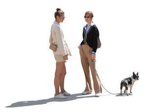two backlit women and a dog standing and talking