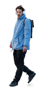 man in a blue jacket wearing headphones walking