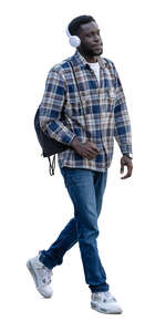 young black man with headphones and backpack walking