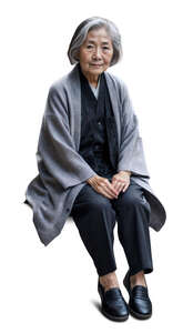 elderly asian woman wearing a grey jacket sitting