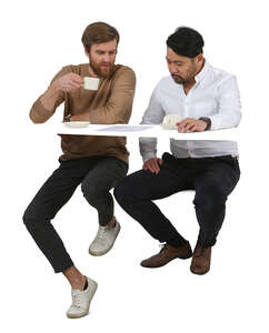 two men sitting in a coffee bar and talking