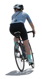 backlit female cyclist riding a bike