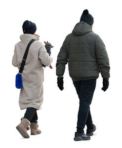 man and woman with a little dog walking in winter
