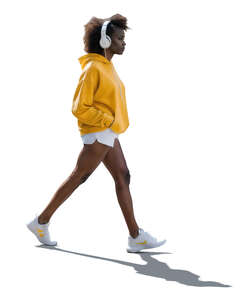 backlit black woman with headphones walking