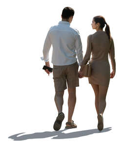 backlit couple walking hand in hand