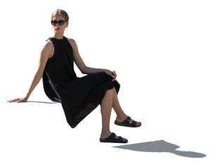 woman in a black summer dress sitting