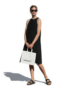 woman in a black dress with a shopping bag standing