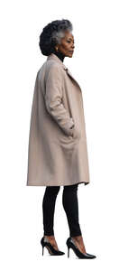cut out grey haired black woman in a beige overcoat standing