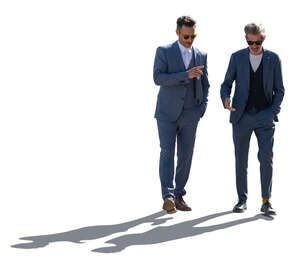 backlit men wearing suits walking