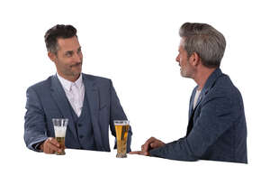 two cut out businessmen standing at the bar counter and drinking beer