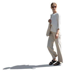 sidelit woman in relaxed white outfit walking