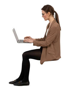 side view of a woman sitting and working with computer