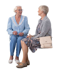 two cut out elderly ladies sitting and talking