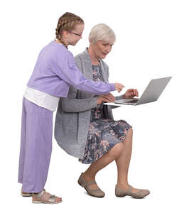 grandchild helping her grandmother with computer
