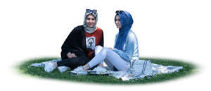 cut out two muslim girls sitting on the grass under a tree