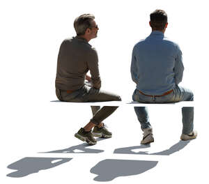 two cut out backlit men sitting seen from back angle