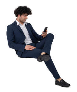 man in a suit sitting and holding a phone