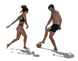 two people playing football on the beach