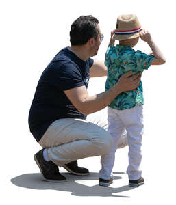 father squatting next to his son and talking