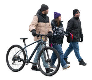cut out group of three people with a bike walking in winter