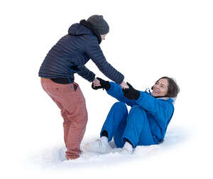 one woman helping another to get up from sitting in snow