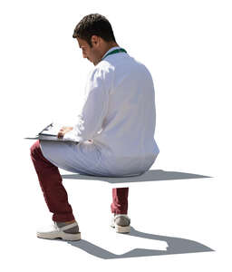 cut out backlit doctor sitting and writing notes