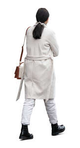 woman wearing a white overcoat walking