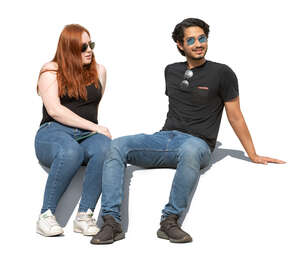 two cut out people sitting outside