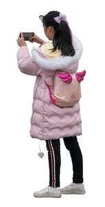 cut out asian girl in a pink coat standing and taking a picture