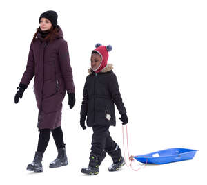 woman and a kid with a sledge walking