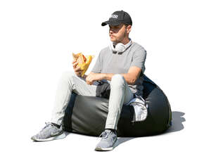 young man sitting and eating a hamburger