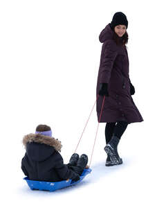 woman pulling a sledge with a girl sitting in it
