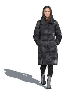 cut out woman in a black puffer coat walking on a sunny day