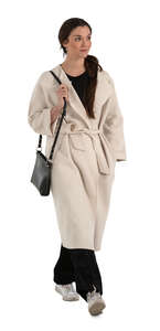 cut out woman in a white overcoat walking