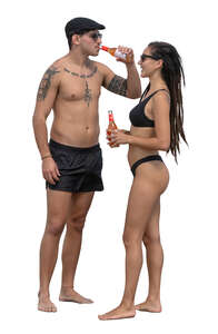 man and woman standing on the beach and drinking refreshing drinks