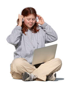 teenage girl sitting with computer and listening to music